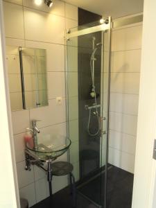 a bathroom with a glass sink and a shower at La Cachette du Menuisier in Waimes