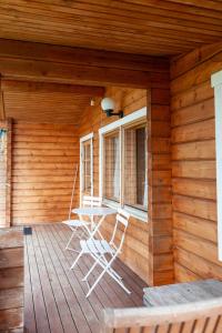 une terrasse couverte en bois avec une table et des chaises. dans l'établissement Katriina, huom! sijaitsee saaressa, locates on island, à Tahkovuori
