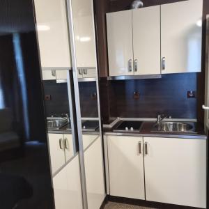a kitchen with white cabinets and a sink at Хотел Европа in Montana