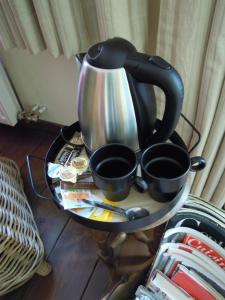 a tea kettle and two cups on a table at La Cachette du Menuisier in Waimes