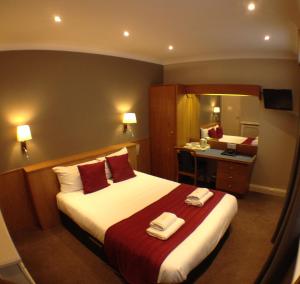 Una habitación de hotel con una cama con toallas. en Columbus Hotel en Londres