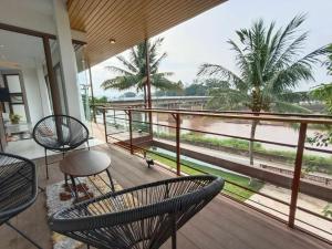 een balkon met stoelen en uitzicht op het water bij Pool Villa Nam Nan in Nan