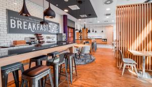 a bar in a restaurant with chairs and tables at Premier Inn Mannheim City Centre in Mannheim