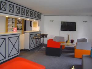 - un salon avec un bar et une télévision dans l'établissement Hotel Pavillon des Gatines, à Plaisir