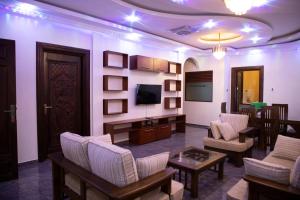 uma sala de estar com cadeiras, uma televisão e uma mesa em WIMAL PALACE em Jaffna