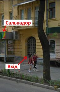duas pessoas a andar numa rua em frente a um edifício em Pushkinskaya "Wine palette" em Kharkov