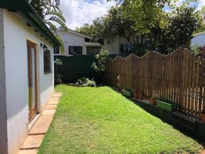 a yard with a fence and a house at Modern Industrial Cottage in Kingsburgh