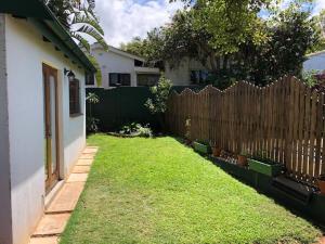 einen Hof mit einem Zaun und einem Haus in der Unterkunft Modern Industrial Cottage in Kingsborough