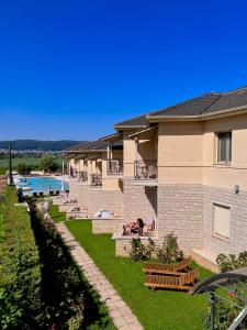 a building with a yard with benches and a pool at Anemolia Resort and Spa in Ioannina