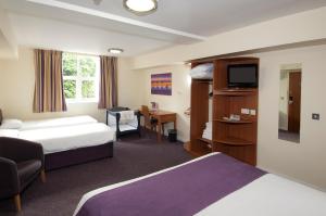 um quarto de hotel com duas camas e uma televisão em The Milestone Peterborough Hotel - Sure Collection by BW em Peterborough