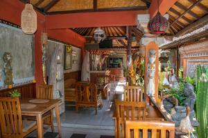 a restaurant with wooden tables and chairs in a room at Down The Rabbit Hole in Ubud