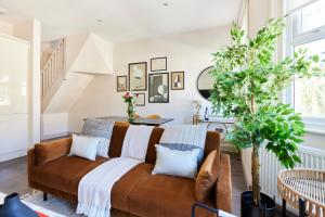 uma sala de estar com um sofá castanho em The Kilburn Crib - Stunning 3BDR Flat em Londres