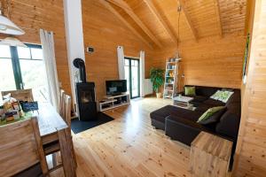 uma sala de estar com um sofá e uma televisão em 5 Sterne Ferienhaus Susi mit Kamin, Seeblick und 2 Terrassen em Rieden