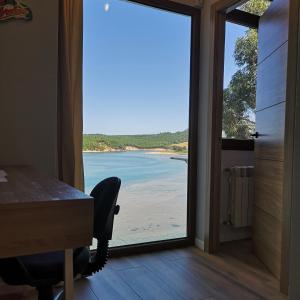 d'un bureau avec une porte coulissante en verre offrant une vue sur la plage. dans l'établissement El mirador de Mogro, à Mogro