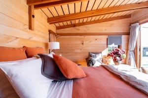 ヘイスティングズにあるFreeFall Hutの木製の壁の客室の大型ベッド1台