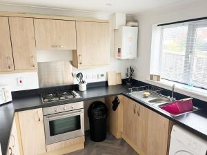 a kitchen with wooden cabinets and a stove top oven at Witton House by Blue Skies Stays in Stockton-on-Tees