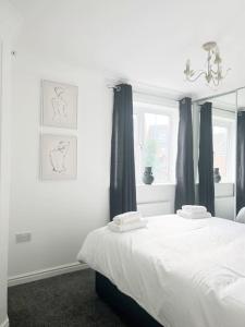 1 dormitorio con cama blanca y espejo en Witton House by Blue Skies Stays, en Stockton-on-Tees