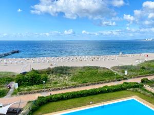 a view of a beach with a swimming pool and the ocean at Prinz Hamlet "Godewind" in Pelzerhaken
