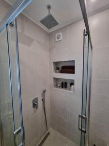 uma casa de banho com um chuveiro e uma porta de vidro em Apartment Polina - 2BD Next to Sea Garden Varna em Varna City