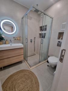 uma casa de banho com um chuveiro, um WC e um lavatório. em Apartment Polina - 2BD Next to Sea Garden Varna em Varna City
