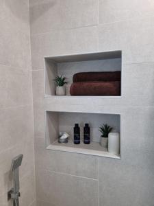 uma casa de banho com uma prateleira com uma toalha e plantas em Apartment Polina - 2BD Next to Sea Garden Varna em Varna City