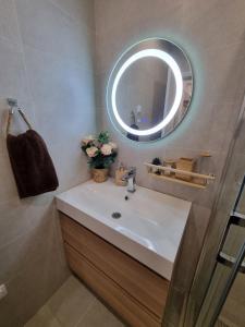 uma casa de banho com um lavatório e um espelho em Apartment Polina - 2BD Next to Sea Garden Varna em Varna City