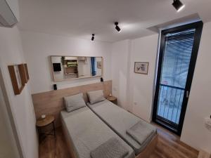 um quarto com uma cama e uma grande janela em Apartment Polina - 2BD Next to Sea Garden Varna em Varna City