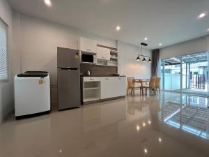 a kitchen with white appliances and a dining room at MOST Family 40 Ubon in Ubon Ratchathani