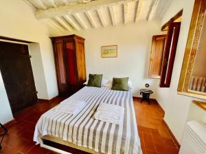 ein Schlafzimmer mit einem Bett mit einer gestreiften Decke in der Unterkunft B&B VALLE D'ORO in Ansedónia