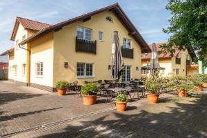 a building with a patio with tables and chairs at Hotel Restaurant Ancho in Cölbe