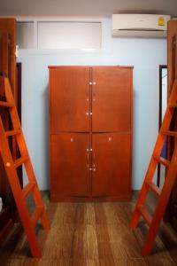 ein großer Holzschrank in einem Raum mit zwei Leitern in der Unterkunft Phangan Barsay Hostel in Thongsala
