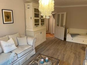 ein Wohnzimmer mit einem weißen Sofa und einem Kronleuchter in der Unterkunft Schnuckenhütte in Soltau
