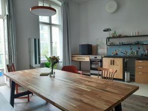 einen großen Holztisch in einer Küche mit Stühlen in der Unterkunft Artist Studio - Berlin - Prenzlauer Berg in Berlin