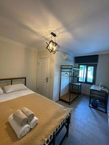 Zu Tiny House Hotel & Restaurant في أورلا: غرفة نوم عليها سرير وفوط