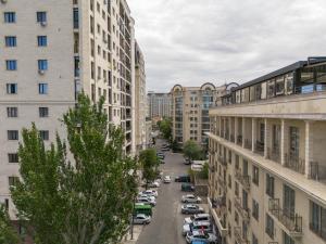 a city street with cars parked in the middle of buildings at Ambassador Hotel in Bishkek