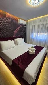 Un dormitorio con una cama grande con una toalla. en City Center Apartment, en Tirana