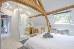 um quarto com uma cama branca e um chuveiro em Le Petit Château de Conteville em Paluel