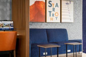 a blue couch in a room with two tables at Holiday Inn Express - Strathroy, an IHG Hotel in Strathroy