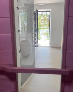 a glass pivot door in a room with a window at Pieds dans l'eau Private Wellness Bordure de Meuse in Lustin