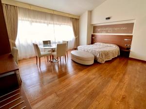 una camera con letto, tavolo e sedie di Hotel Lovere Resort & Spa a Lovere