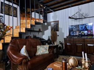 sala de estar con sofá de cuero marrón y mesa en Çiftlik ve Dağ evi Kemer - Canerbey, en Kemer