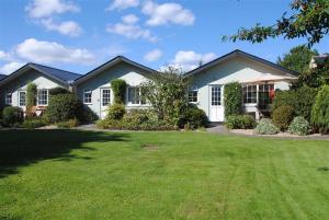 une maison avec une pelouse devant elle dans l'établissement Avocet at Leigh Cottages, à Seaton