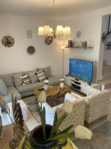 a living room with a couch and a tv at La Vida Villa Alcudia Smir Fnideq, Holiday Homes in Tetouan