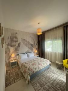 Un dormitorio con una cama grande y una pared en La Vida Villa Alcudia Smir Fnideq, Holiday Homes, en Tetuán