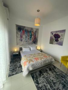 テトゥアンにあるLa Vida Villa Alcudia Smir Fnideq, Holiday Homesのベッドルーム1室(ベッド1台付)が備わります。壁には絵画2点が飾られています。