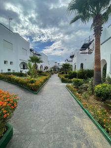 得土安的住宿－La Vida Villa Alcudia Smir Fnideq, Holiday Homes，一条在大楼旁的棕榈树走道