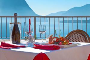 un tavolo con una bottiglia di vino e bicchieri da vino di Hotel Lovere Resort & Spa a Lovere