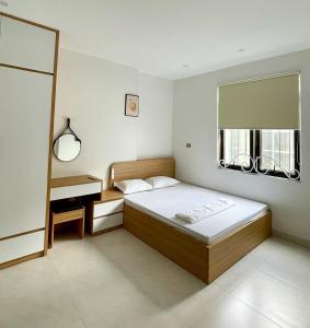 a bedroom with a bed and a desk and a window at Crabby homes in Hanoi