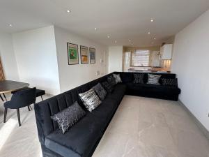 a black leather couch in a living room at Queens Apartment 1 in Blackpool