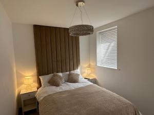 1 dormitorio con 1 cama con 2 mesitas de noche y 2 lámparas en Queens Apartment 1 en Blackpool